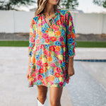 Front view of Viola Mini Dress with tiered skirt, tie front detail, and ruffled 3/4 sleeves.