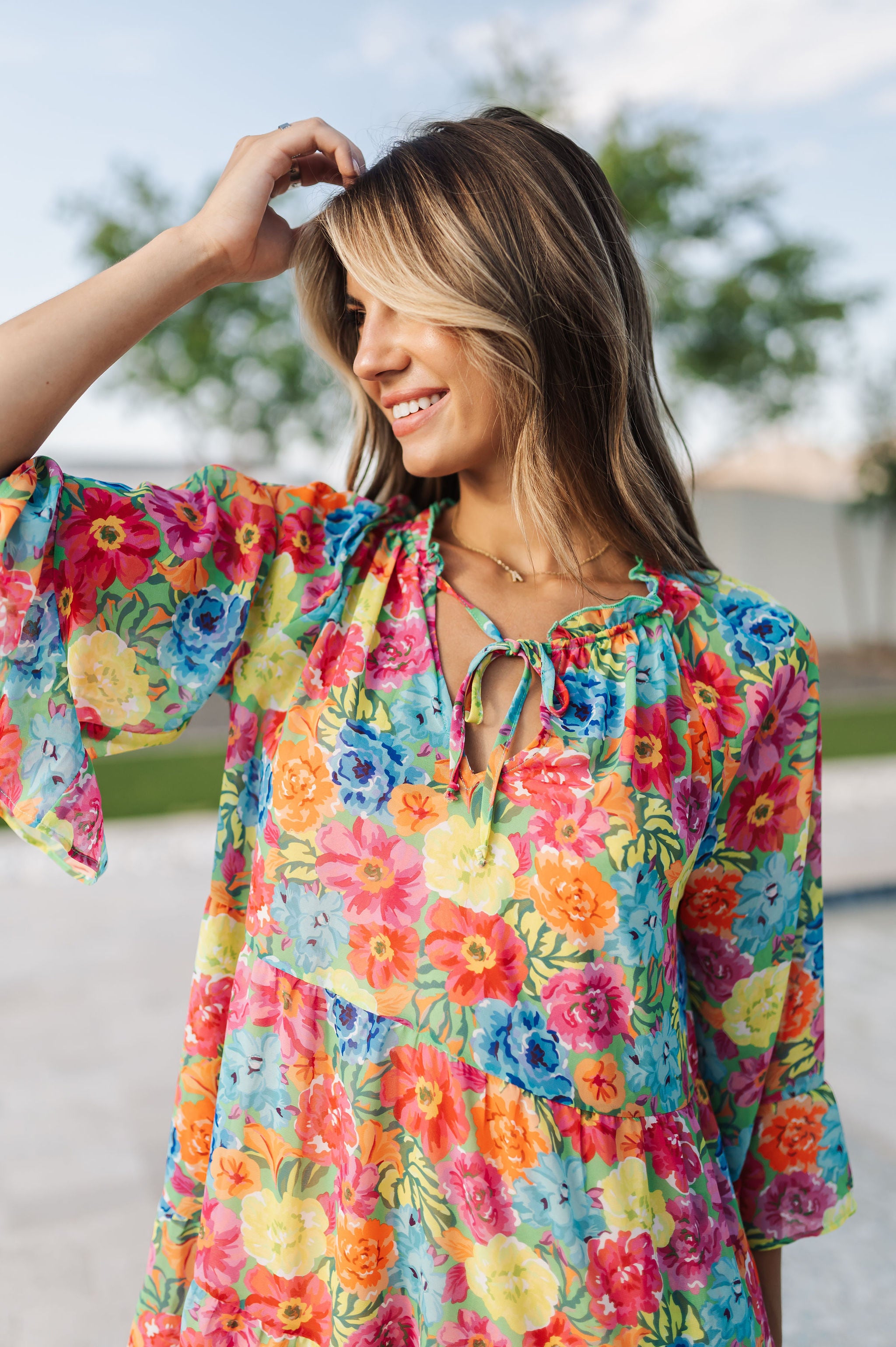 Close up view of Viola Mini Dress with tie front detail and ruffled 3/4 sleeves and neckline.