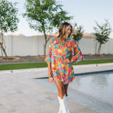 Front view of Viola Mini Dress with tiered skirt, tie front detail, and ruffled 3/4 sleeves.