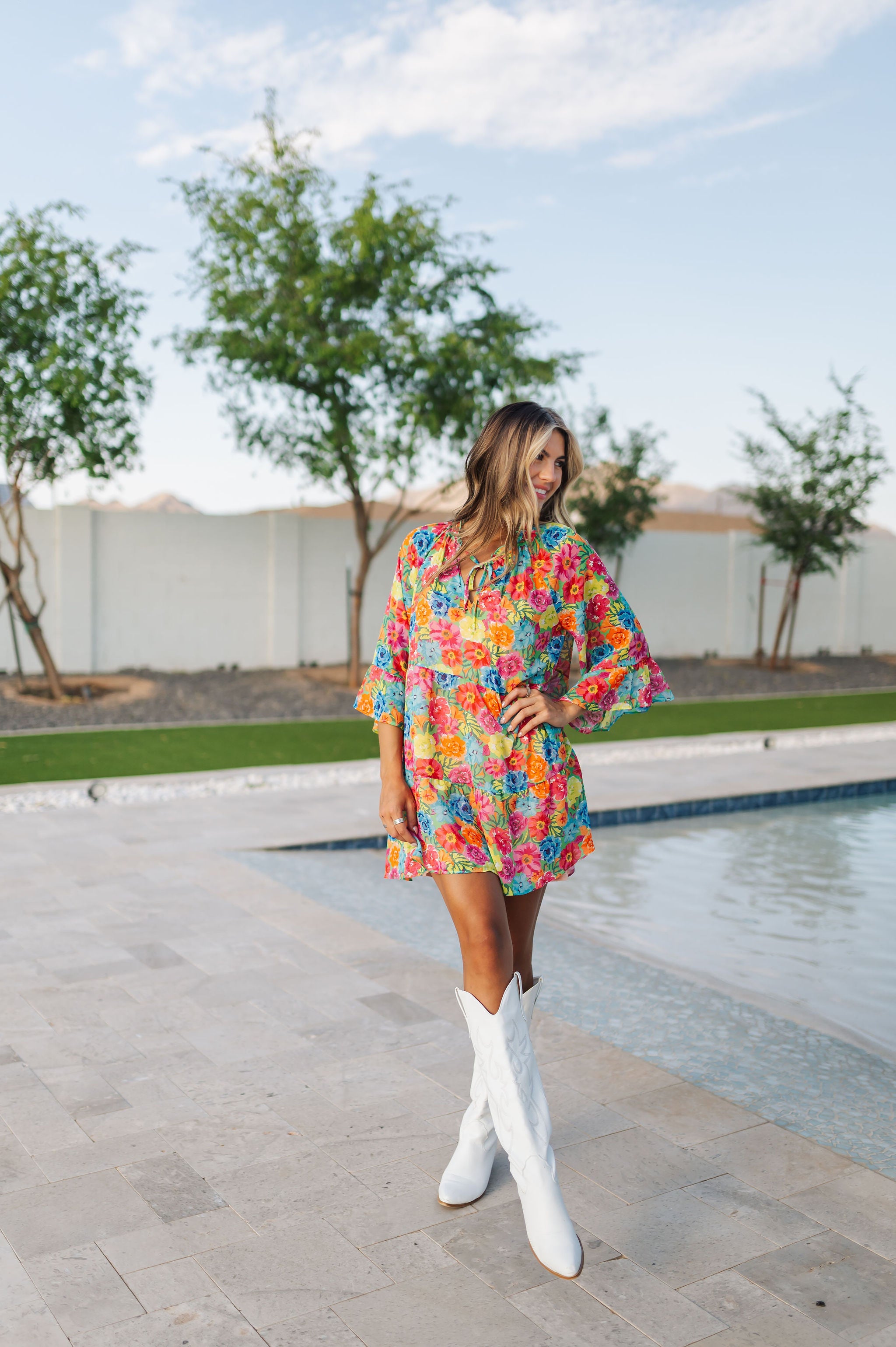 Front view of Viola Mini Dress with tiered skirt, tie front detail, and ruffled 3/4 sleeves.