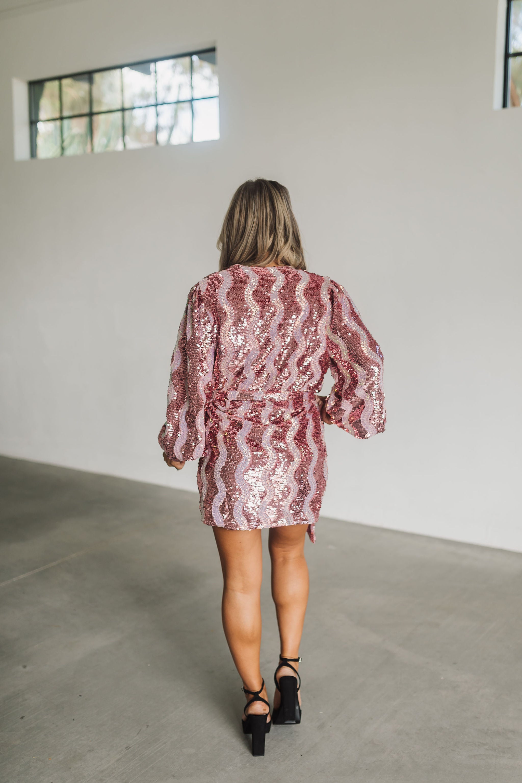 Rear view of wrap Adeline Dress with long puff sleeves and allover zigzag sequin pattern.