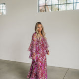 Front angled view of Colette Maxi Dress with V neck, bell sleeves, empire waist, high slit, and allover sequin details.
