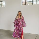 Front view of Colette Maxi Dress with V neck, bell sleeves, empire waist, high slit, and allover sequin details.