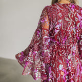 Up close rear view of Colette Maxi Dress with bell sleeves, empire waist, and allover sequin details.