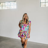 Front view of Elisabeth Romper with allover abstract print, flowy mini skirt, wide straps, and bustier button up front.