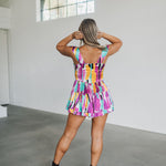 Rear view of Elisabeth Romper with allover abstract print, flowy mini skirt, and wide straps.