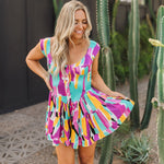 Front view of Elisabeth Romper with allover abstract print, flowy mini skirt, wide straps, and bustier button up front. 