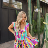 Front view of Elisabeth Romper with allover abstract print, flowy mini skirt, wide straps, and bustier button up front. 