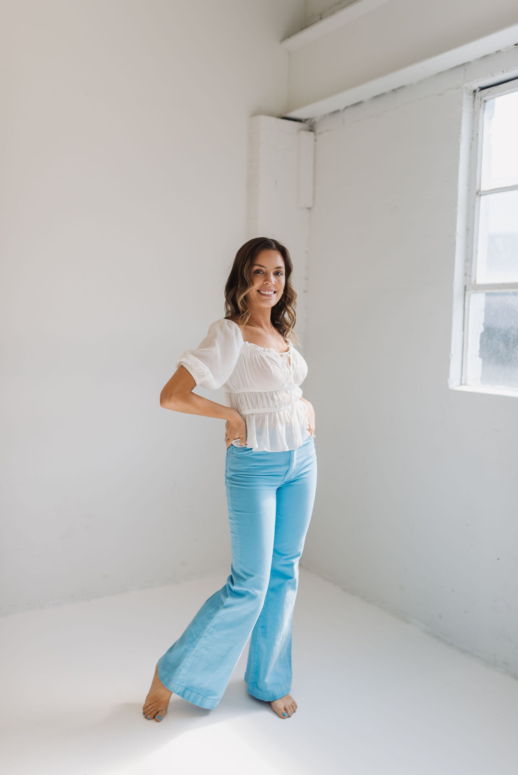 Side angled view of East Coast Flare jeans in blue corduroy with flare leg. 