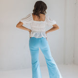 Rear view of East Coast Flare jeans in blue corduroy with flare leg and angled rear pockets.  