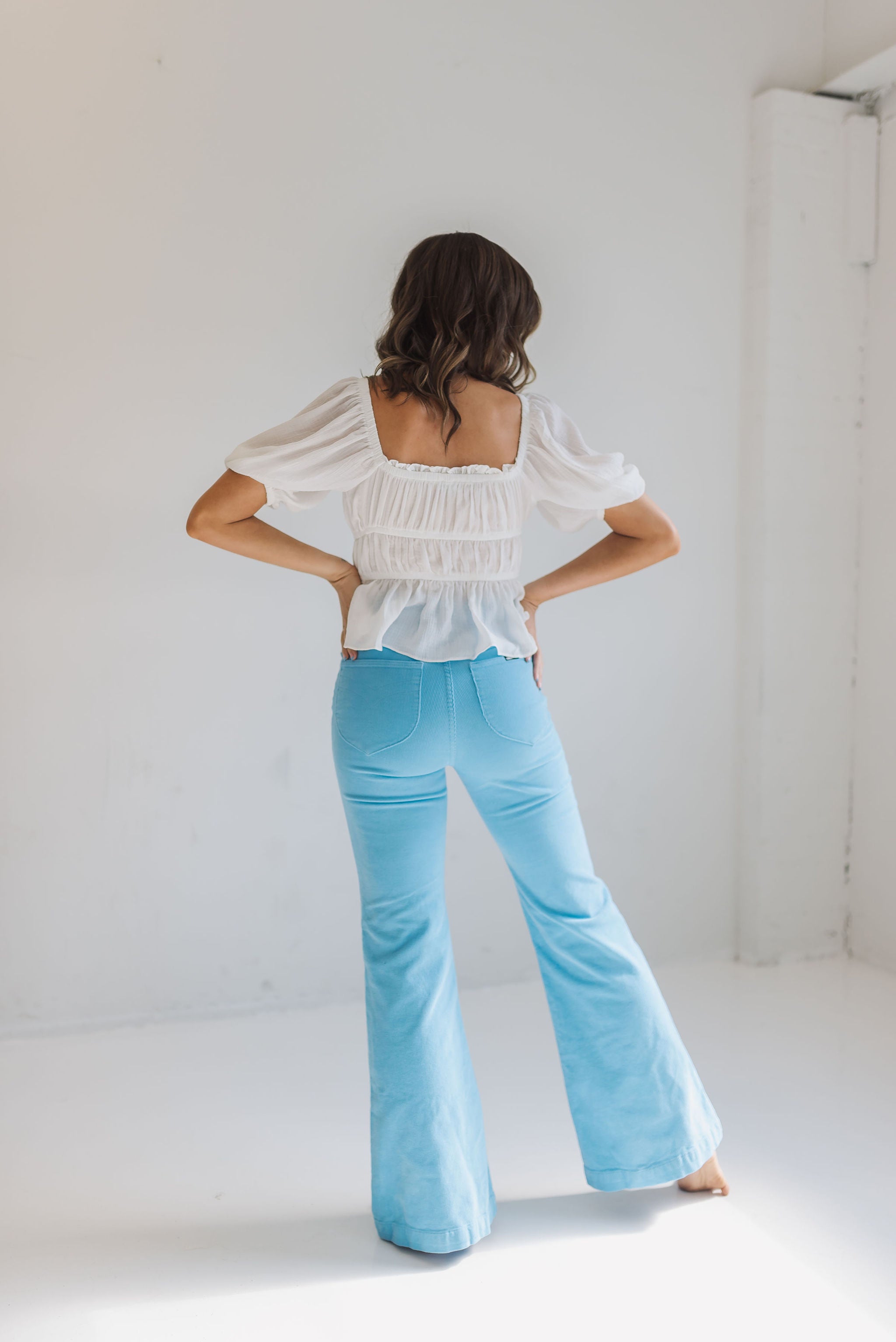 Rear view of East Coast Flare jeans in blue corduroy with flare leg and angled rear pockets.  