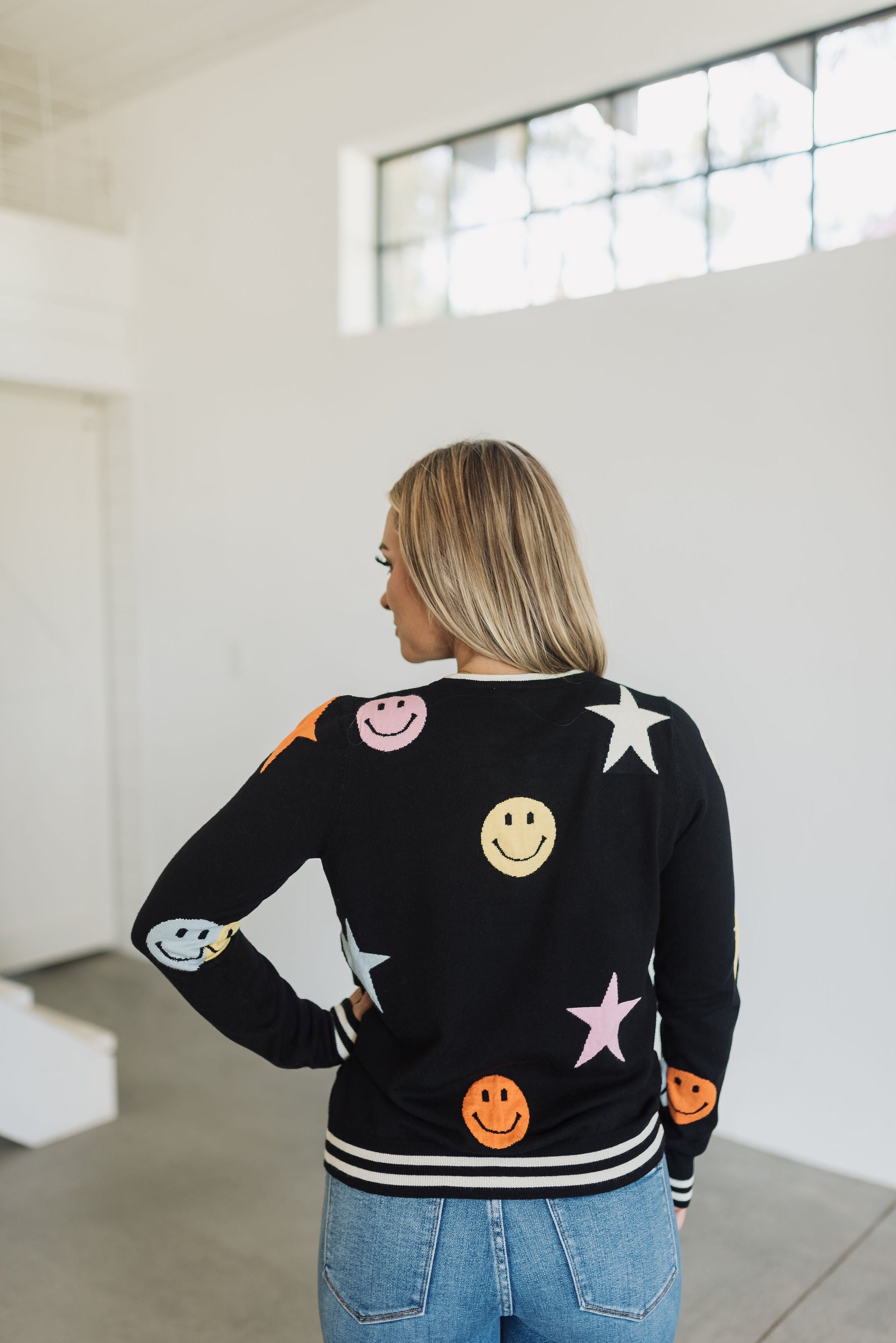 Rear view of Stars And Smiles Sweater with allover stars and smile polka dot pattern. 