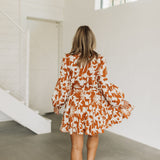 Rear view of Red Rock Floral Dress with tied waist and pleated skirt. 