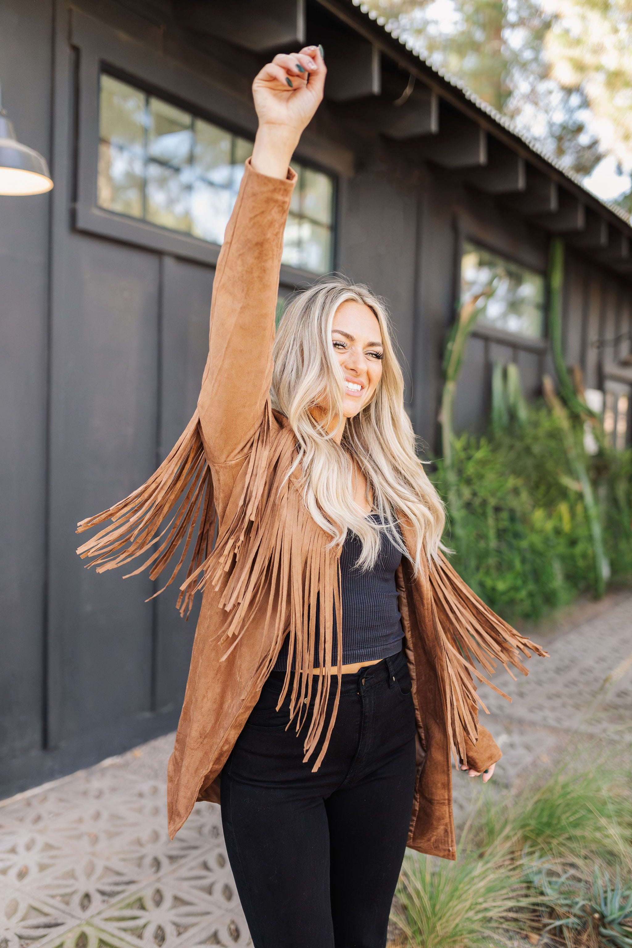 Front angled view of Dutton Fringe Suede Jacket in cocoa with fringe detailing at chest and arms. 