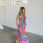 Front angled view of high-low maxi Ipanema Tie Dess with vibrant allover print and tie front. 