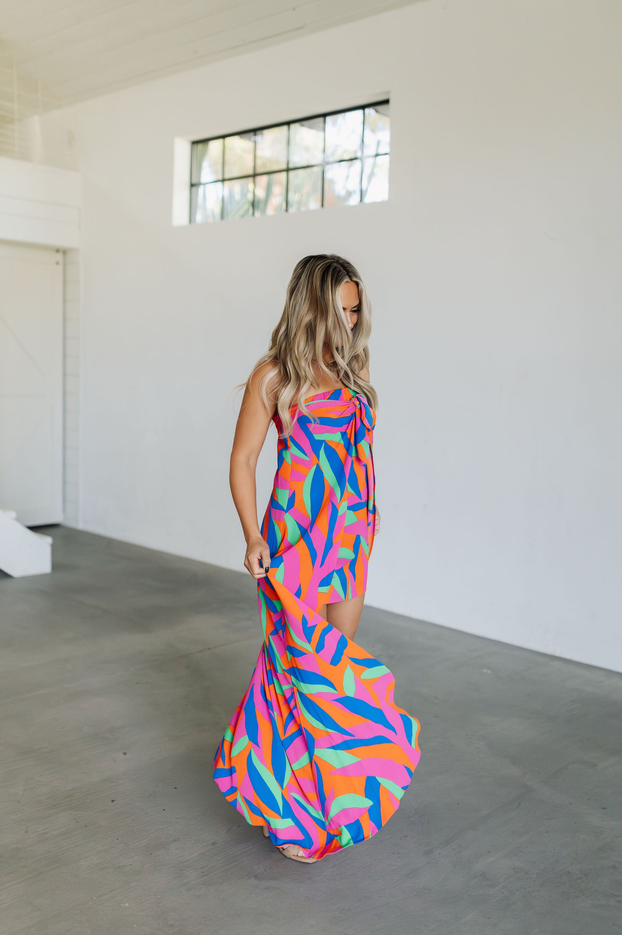 Front angled view of high-low maxi Ipanema Tie Dess with vibrant allover print and tie front. 