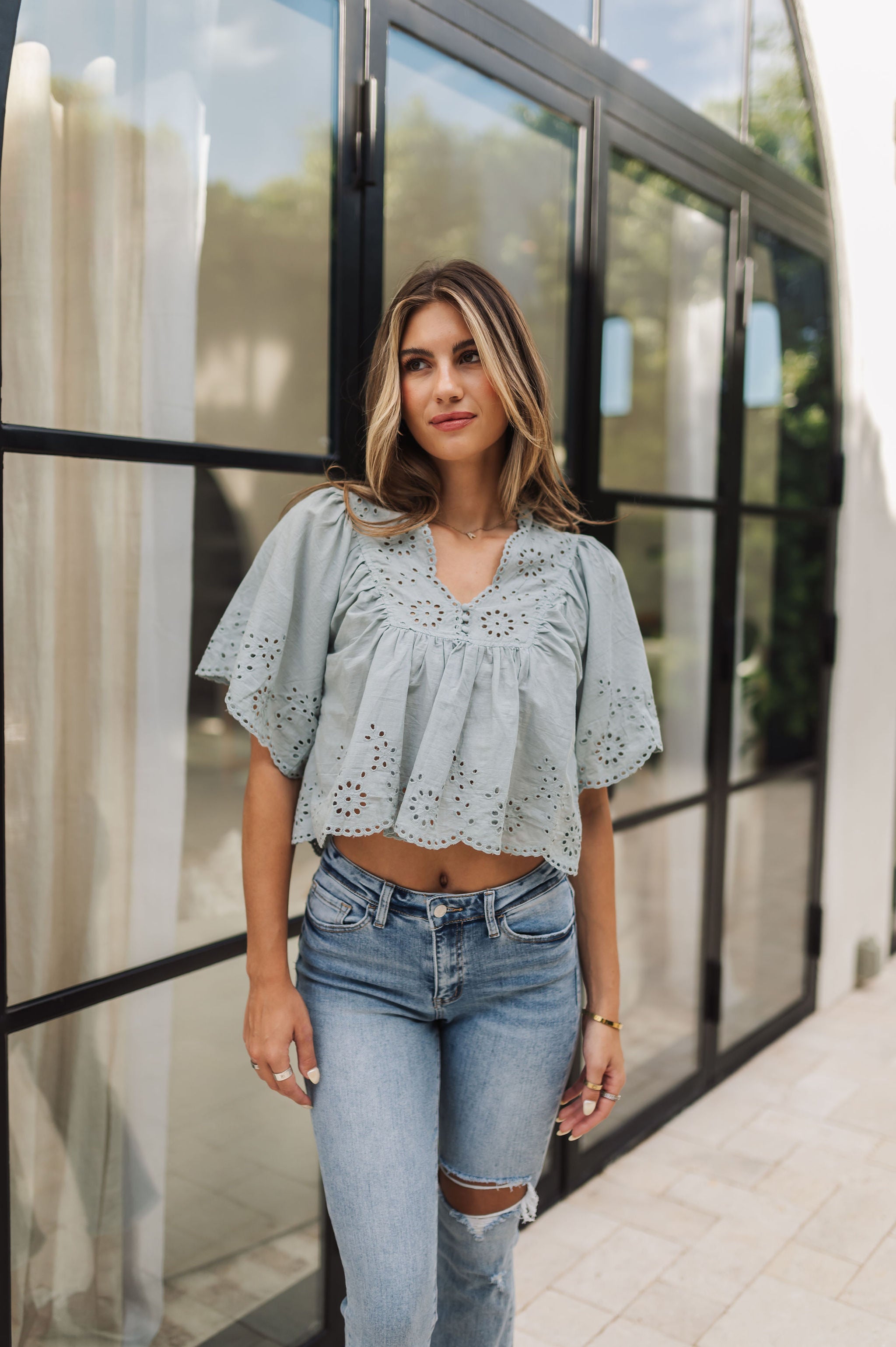 Front view of Whispering Willow Eyelet Top in faded sage color with eyelet details, scalloped edges and button front. 