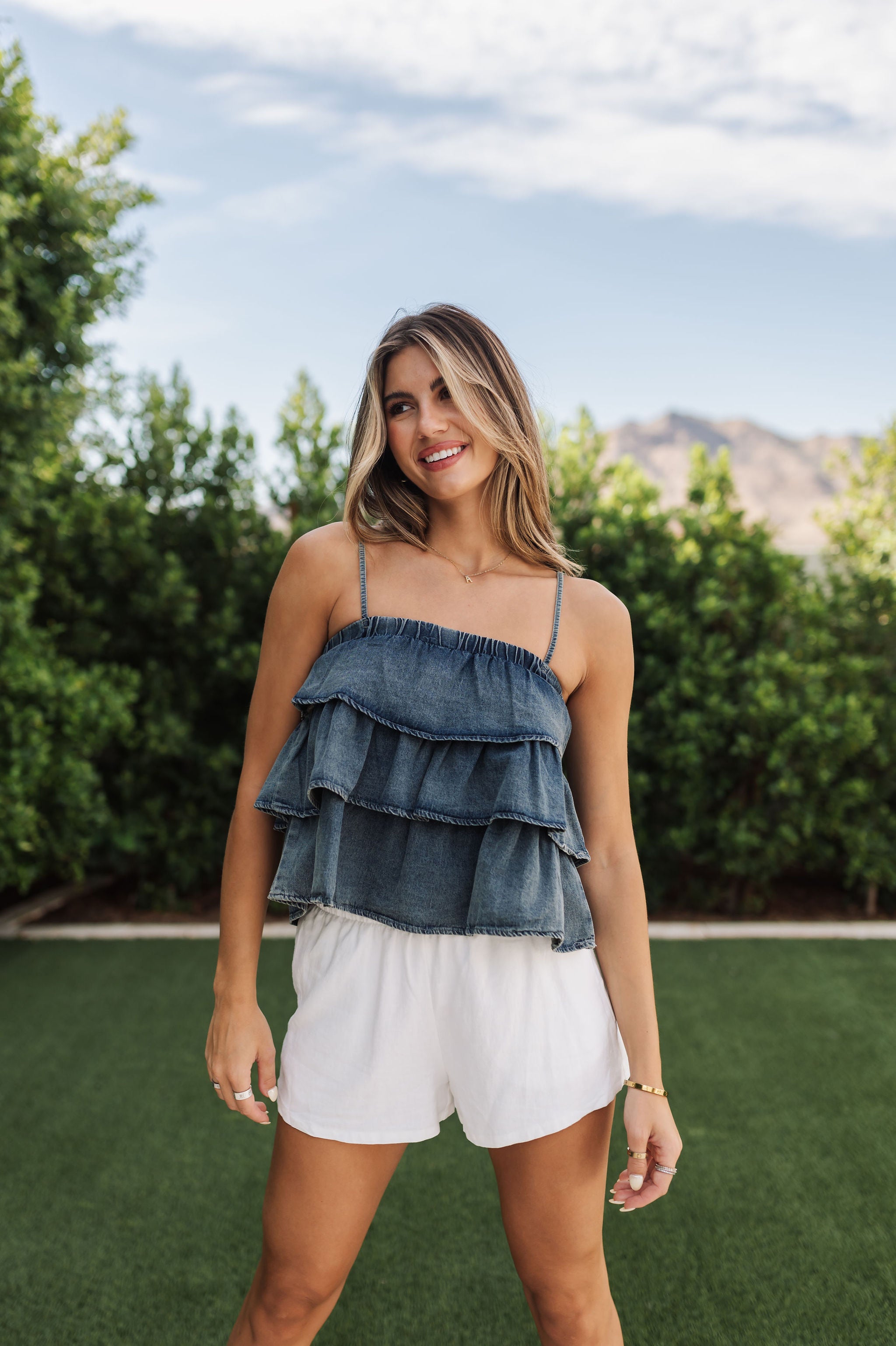 Front view of Ranchers Cascade Tank Top in blue denim color, thin straps, tiered ruffles. 