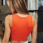 Rear view of Deep Scoop Crop Top in a burnt sienna color with banded hem. 