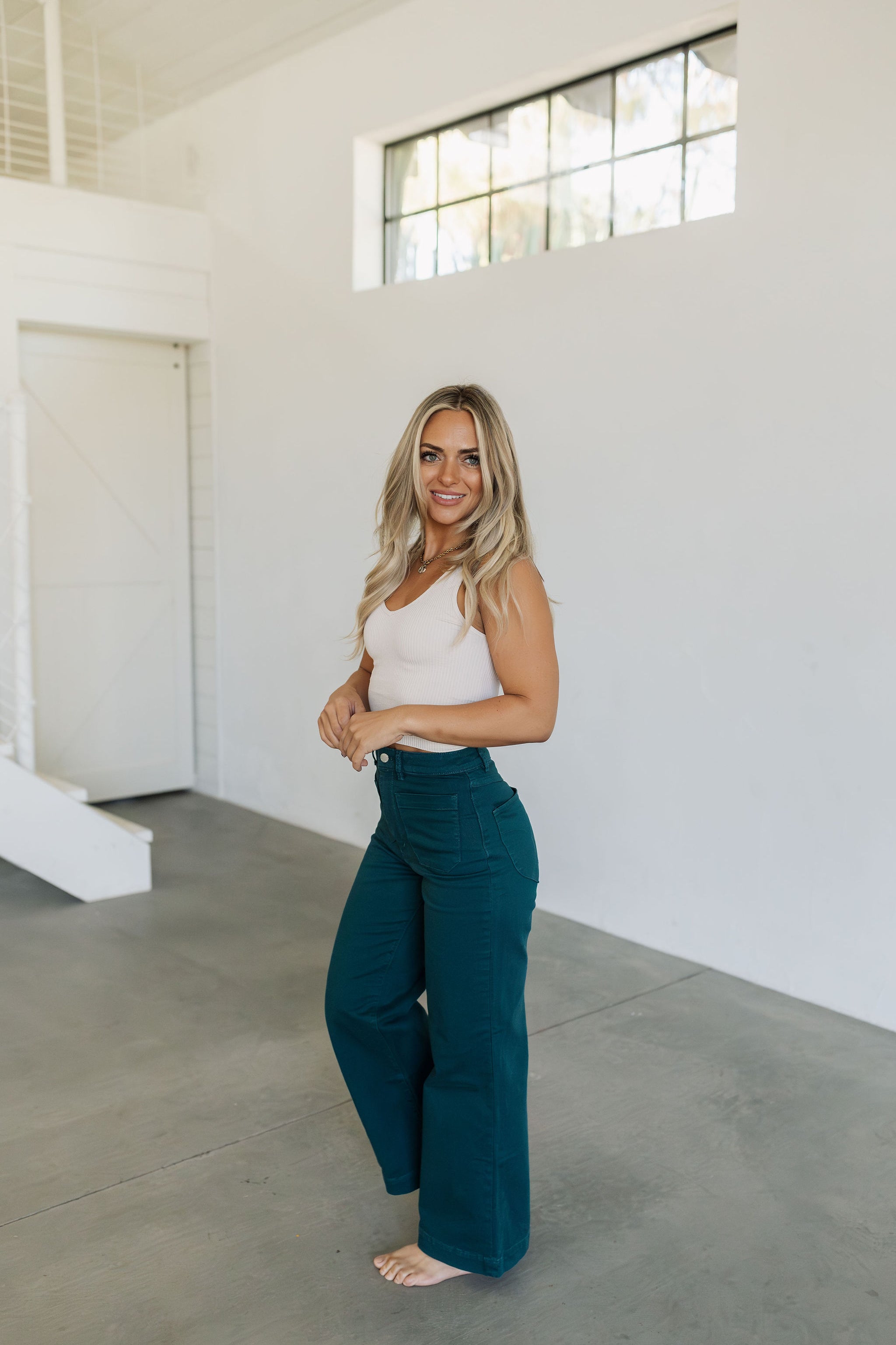 Side view of wide leg Sailor Jeans in forest with sailor style patch front pockets. 