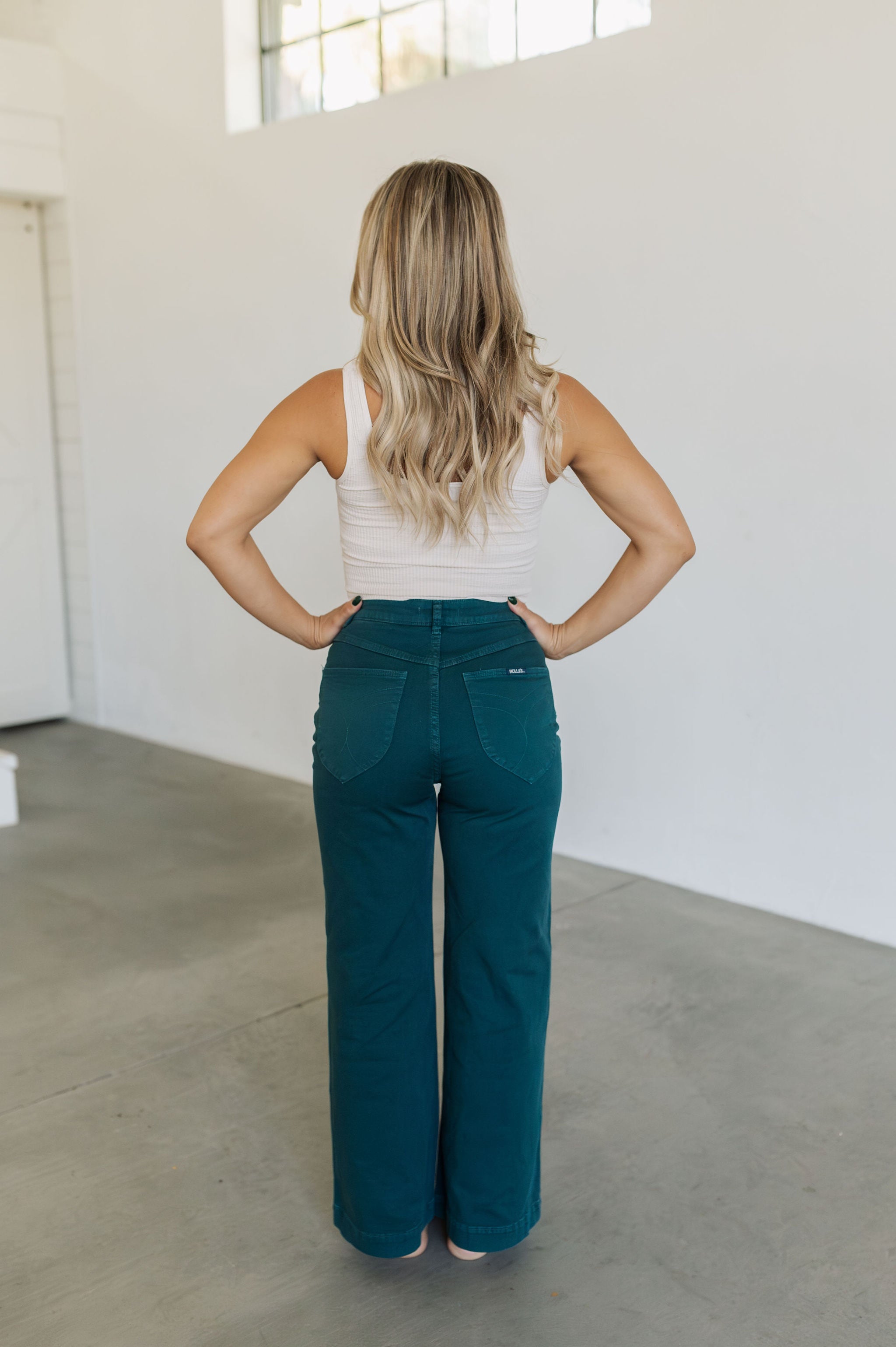 Rear view of wide leg Sailor Jeans in forest with angled rear pockets. 
