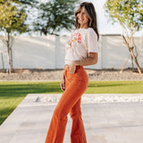 Side view of Eastcoast Flare Cord pants in a rust color and flared leg. 