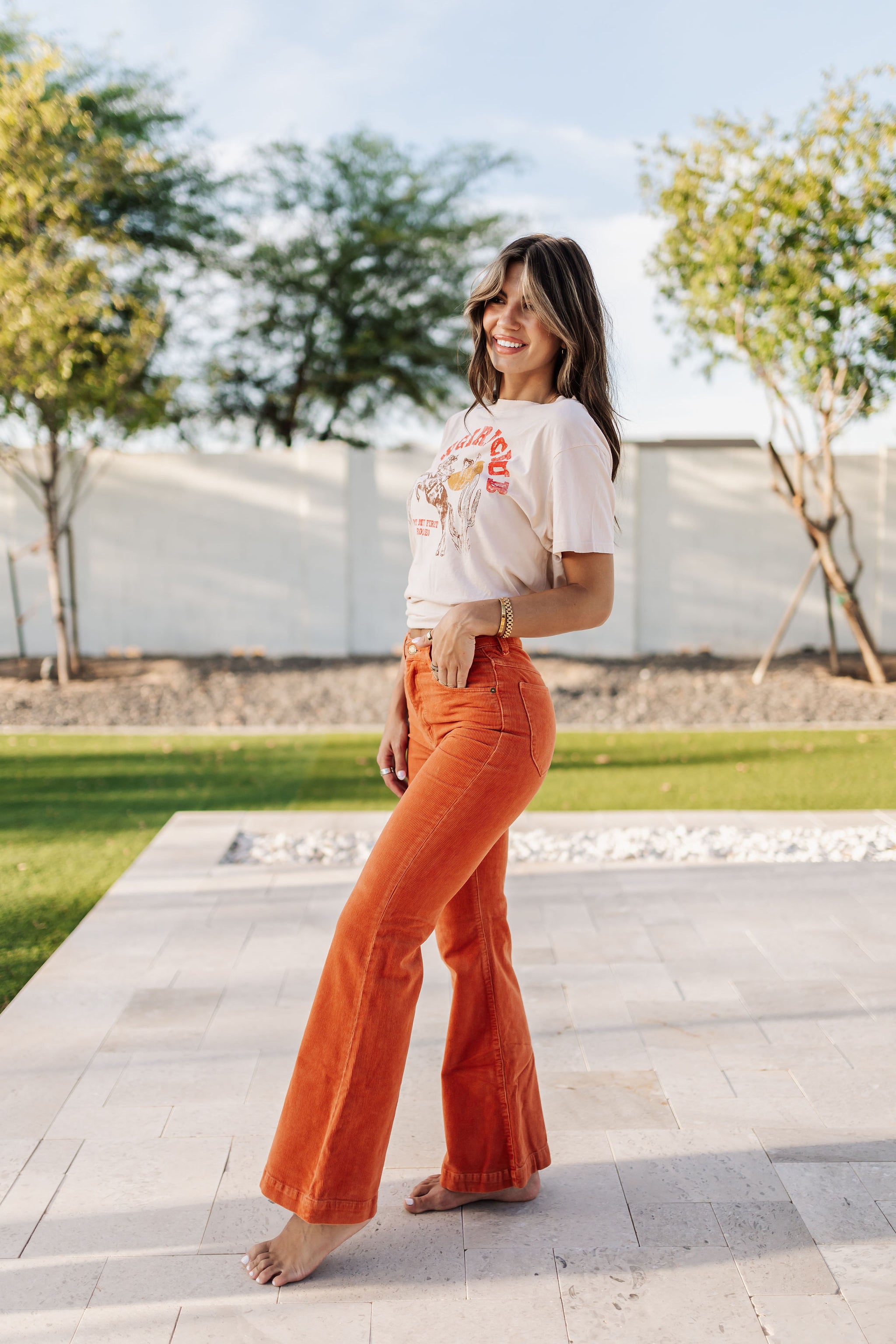 Side view of Eastcoast Flare Cord pants in a rust color and flared leg. 