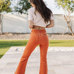 Rear view of Eastcoast Flare Cord pants in a rust color with flared legs and rear pockets. 