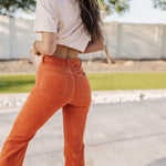 Rear view of Eastcoast Flare Cord pants in a rust color with flared legs and rear pockets. 