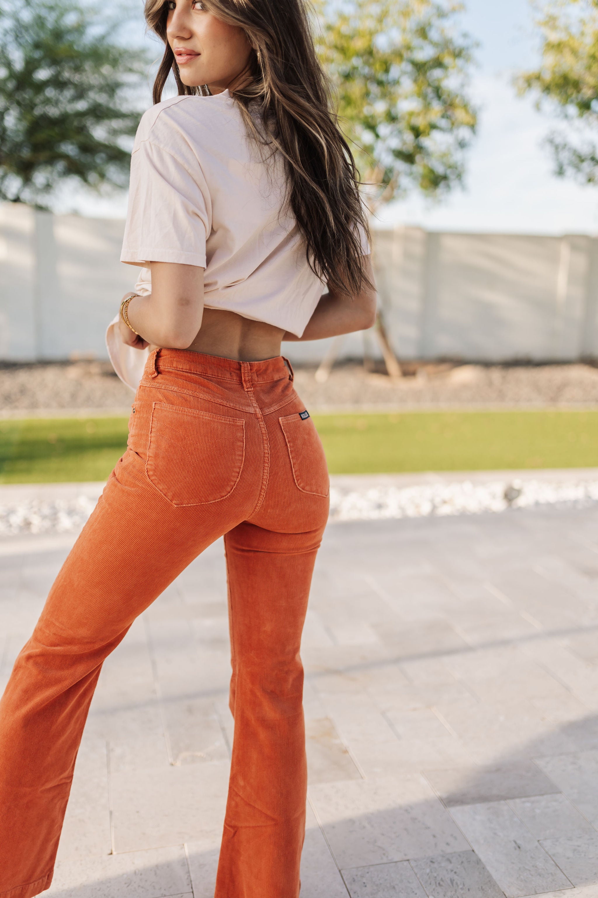 Rear view of Eastcoast Flare Cord pants in a rust color with flared legs and rear pockets. 