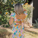 Rear view of Cathy Mini Dress in allover floral print, puff sleeves, and double tie back.
