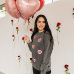 Front angled view of Glitter Hearts Sweatshirt in aged gray with crewneck and glitter details. 