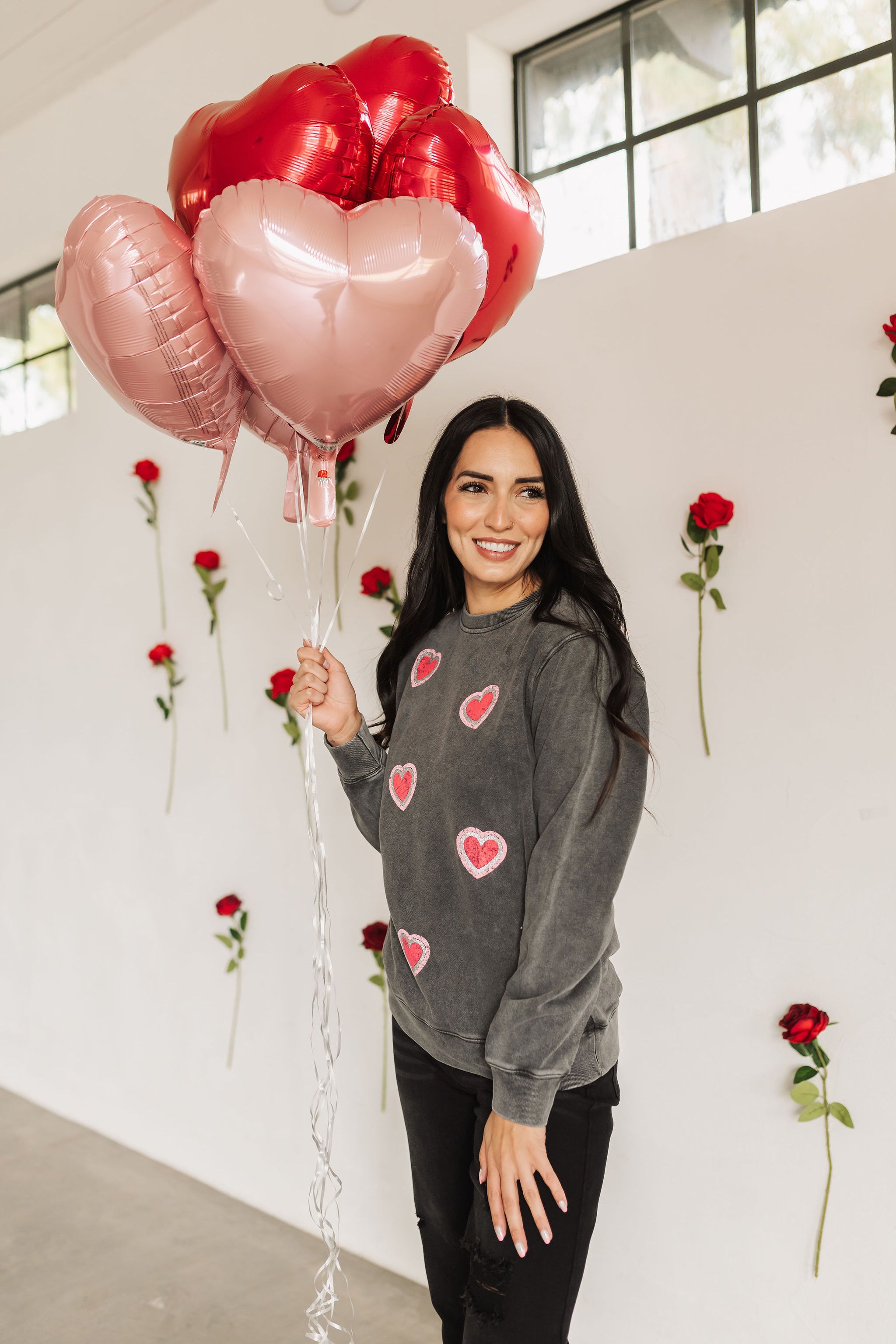 Front angled view of Glitter Hearts Sweatshirt in aged gray with crewneck and glitter details. 