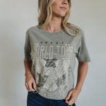 Front view of World Tour Graphic Tee with mineral wash, distressed graphic, and raw hem. 