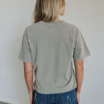 Rear view of World Tour Graphic Tee with mineral wash and raw hem. 