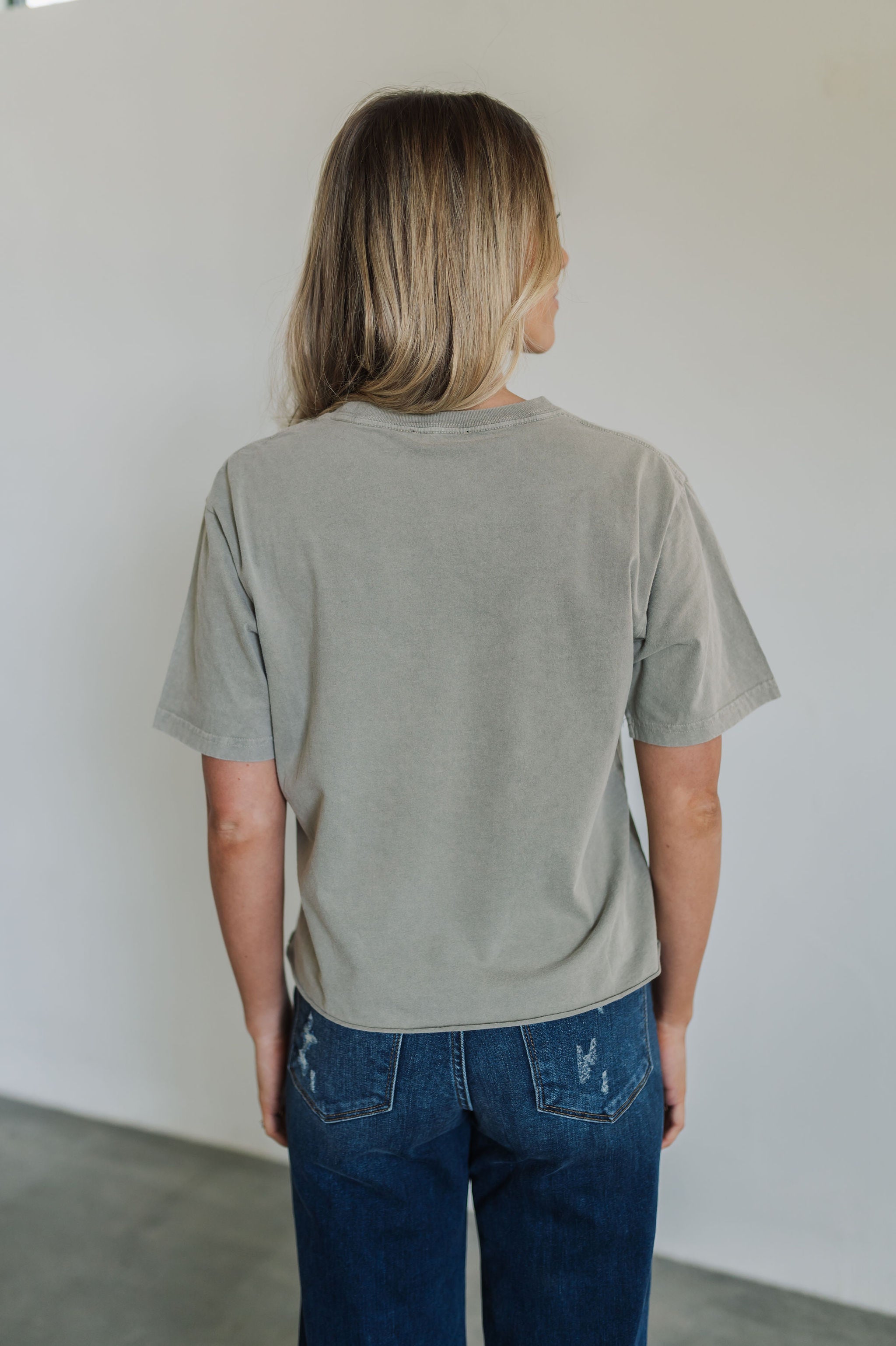 Rear view of World Tour Graphic Tee with mineral wash and raw hem. 