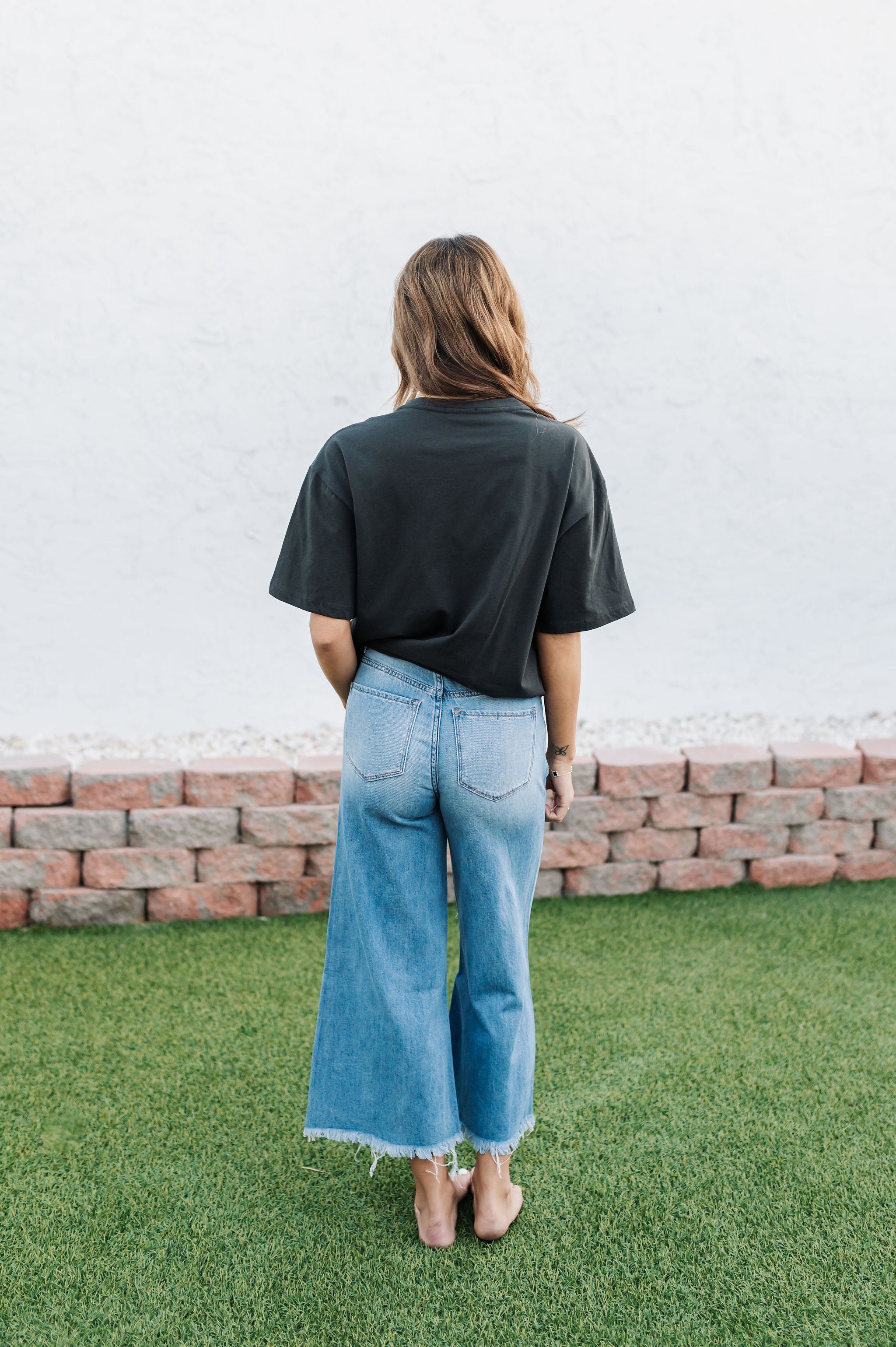 Rear view of Olivia Distressed Jean with copped leg and raw hem. 