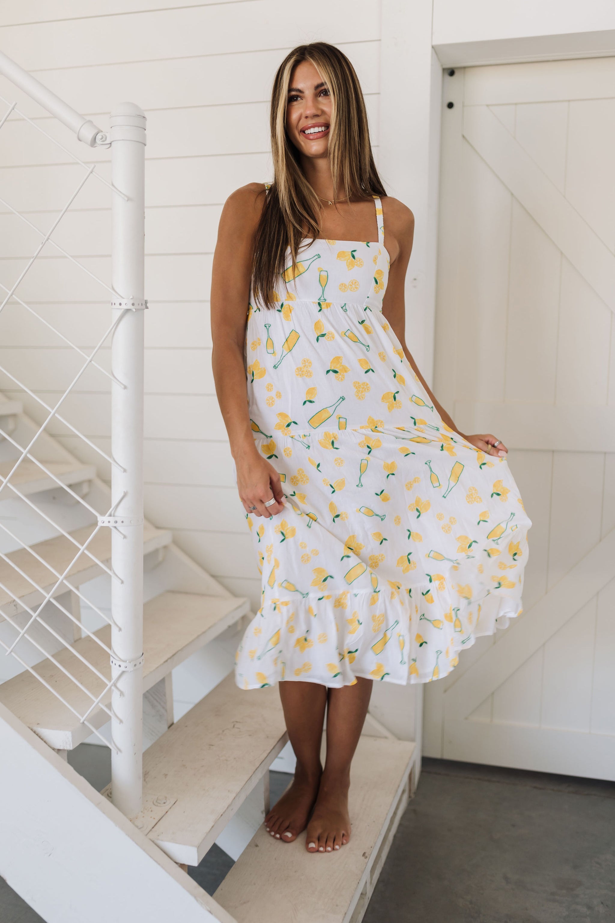 Front view of Summer Fling Midi Dress with embroidered Limoncello print, thin straps, square neckline, and ruffled hem. 
