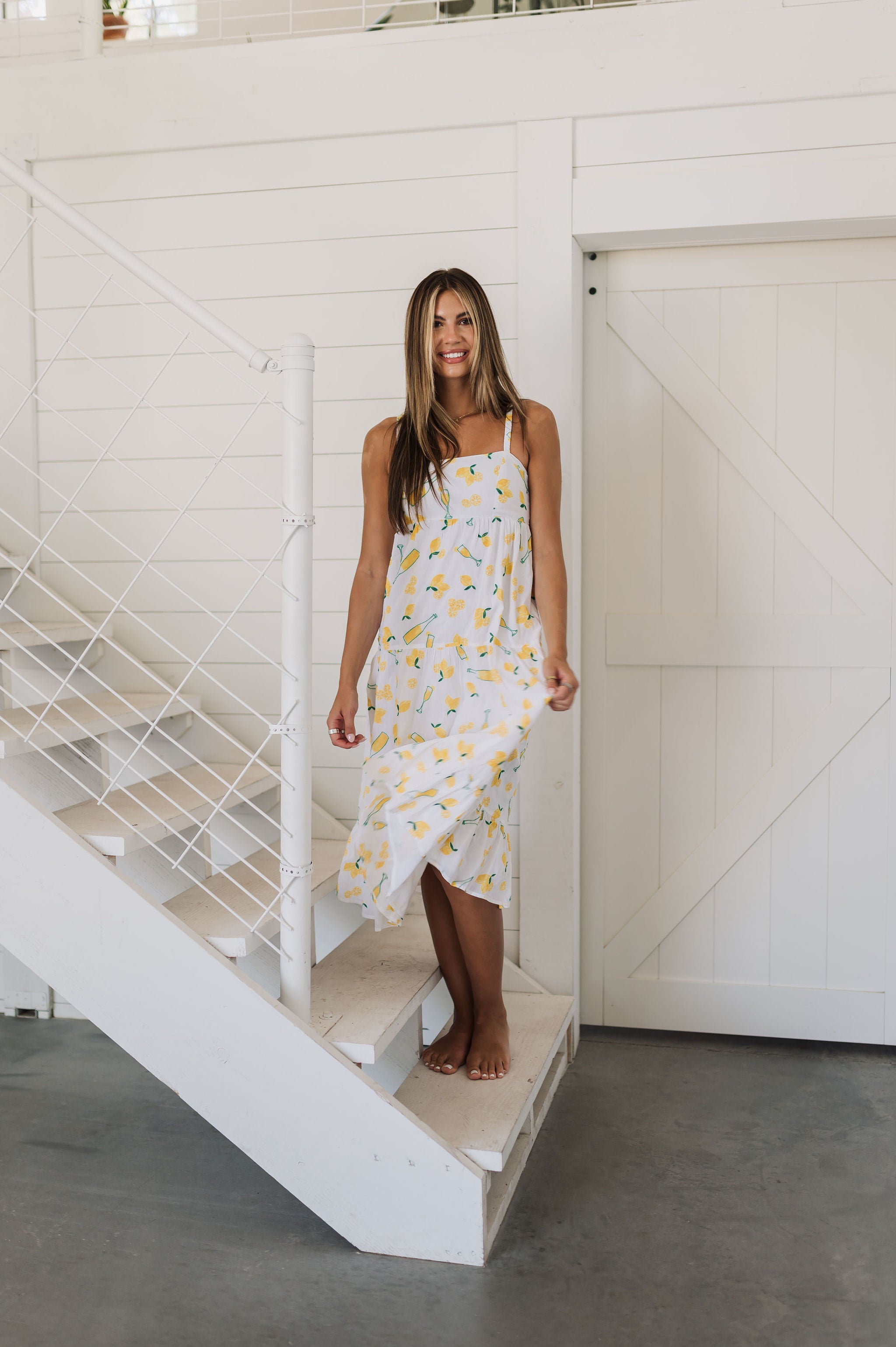 Front view of Summer Fling Midi Dress with embroidered Limoncello print, thin straps, square neckline, and ruffled hem. 