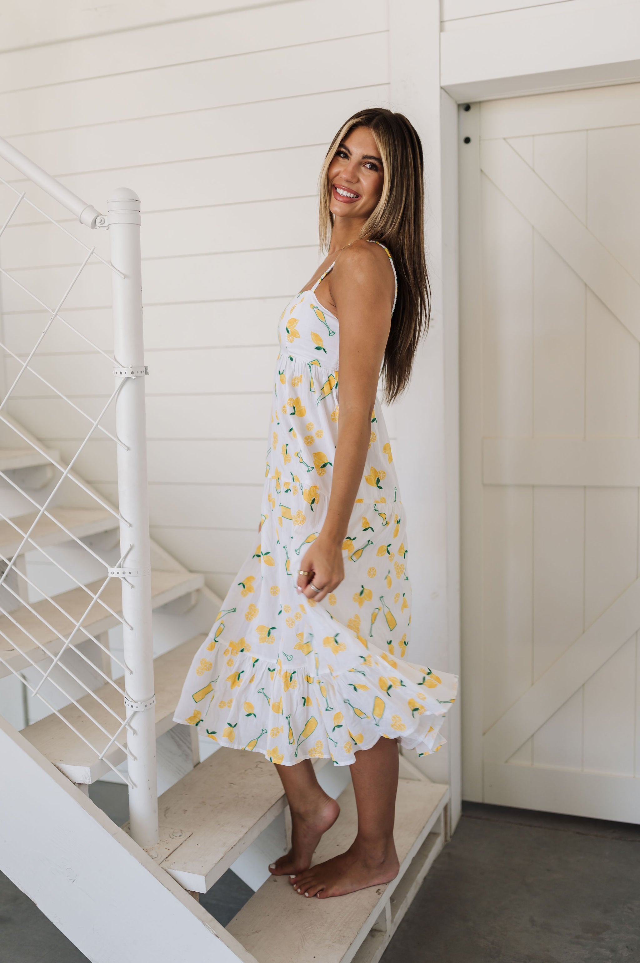 Side view of Summer Fling Midi Dress with embroidered Limoncello print, thin straps, and ruffled hem. 