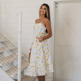 Side view of Summer Fling Midi Dress with embroidered Limoncello print, thin straps, square neckline, side pockets, and ruffled hem.