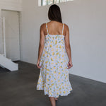 Rear view of Summer Fling Midi Dress with embroidered Limoncello print, thin straps, smocked back, and ruffled hem.