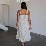 Rear view of Summer Fling Midi Dress with embroidered Limoncello print, thin straps, smocked back, and ruffled hem.