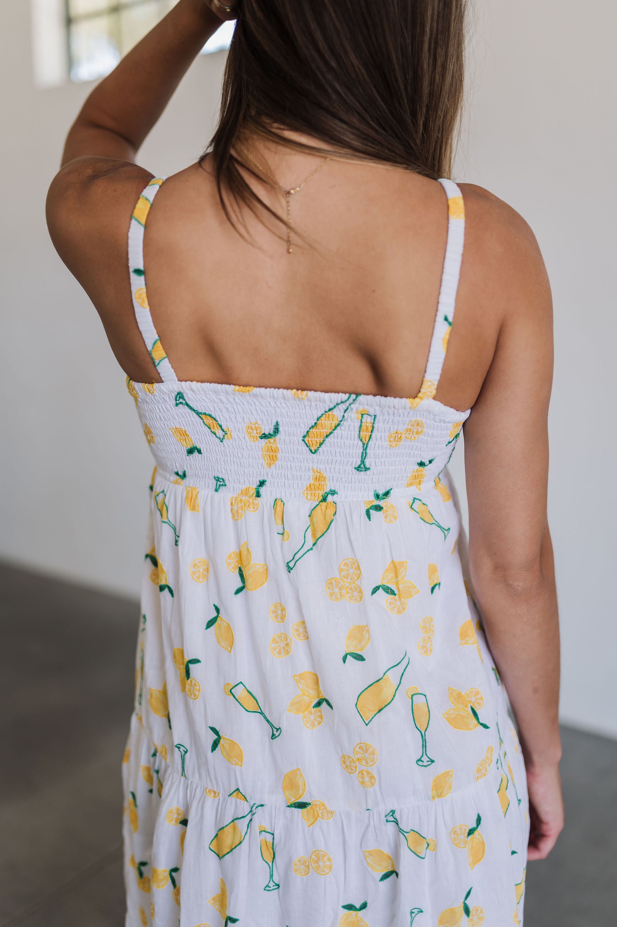 Rear view of Summer Fling Midi Dress with embroidered Limoncello print, thin straps, and smocked back.