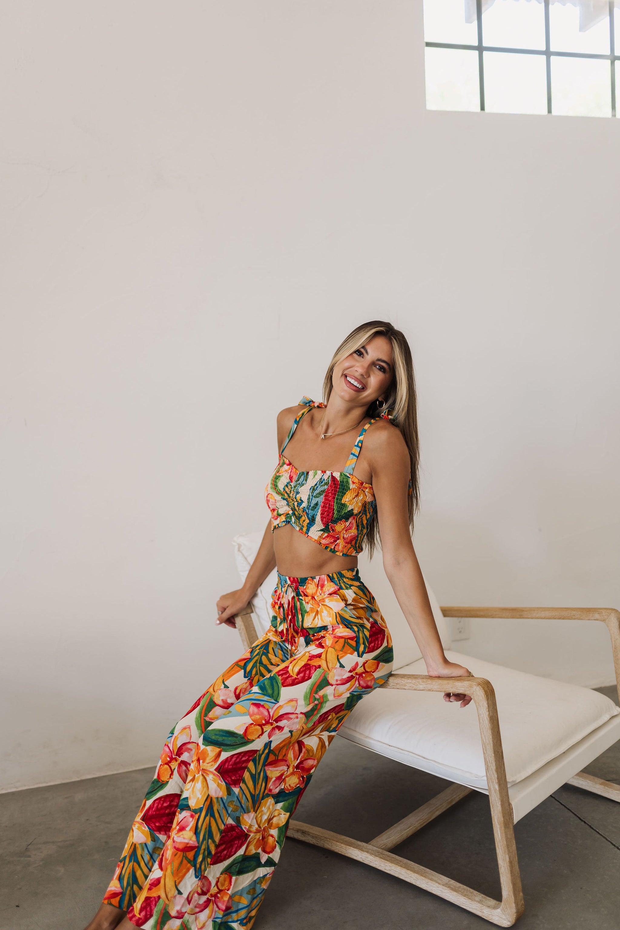 Seated view of St. Tropez Wide Leg Pants with elastic tie waist and allover tropical print. 