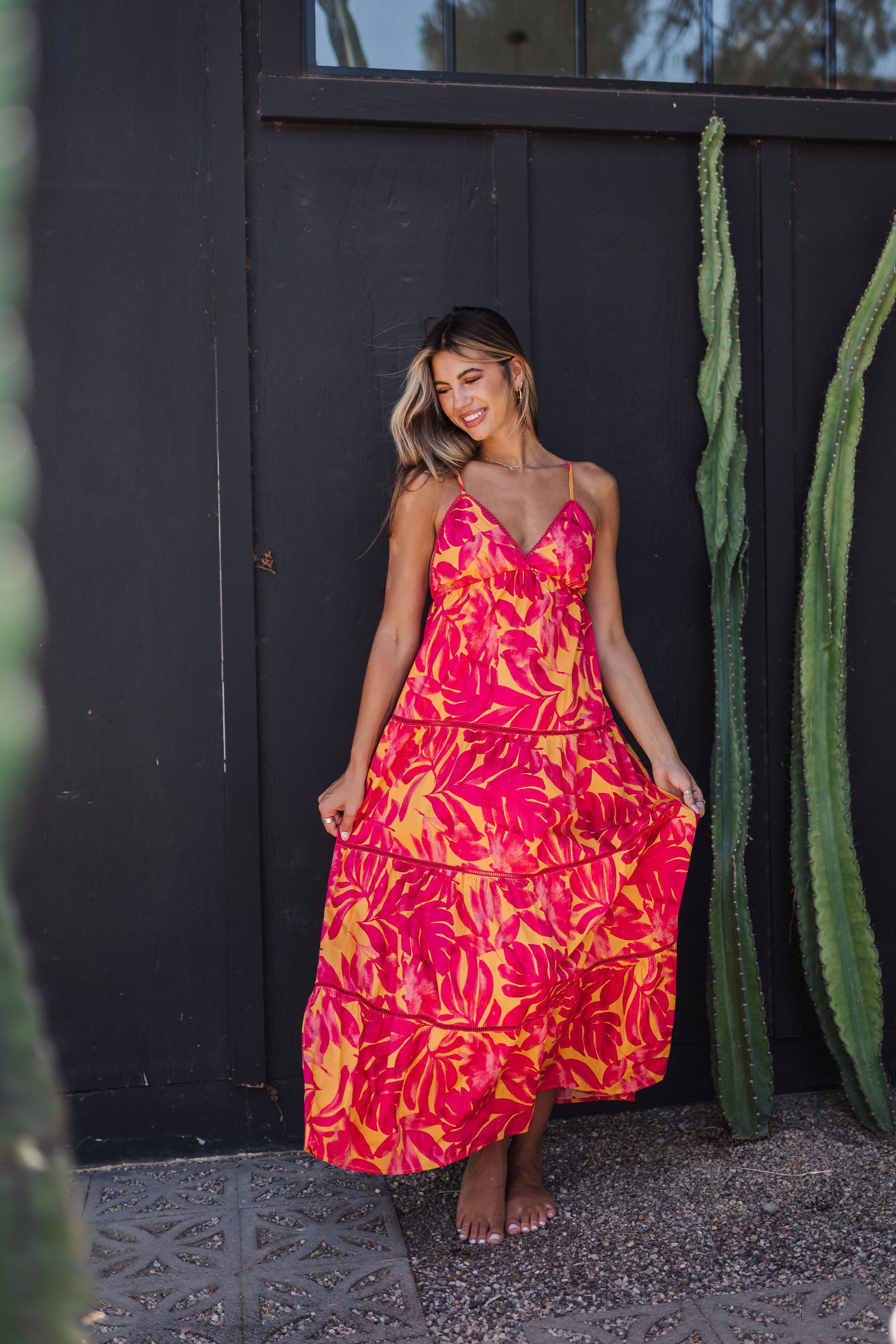 Front view of Amalfi Sunset Maxi Dress with thin straps, deep V-neck, allover neon print, and lace trim. 