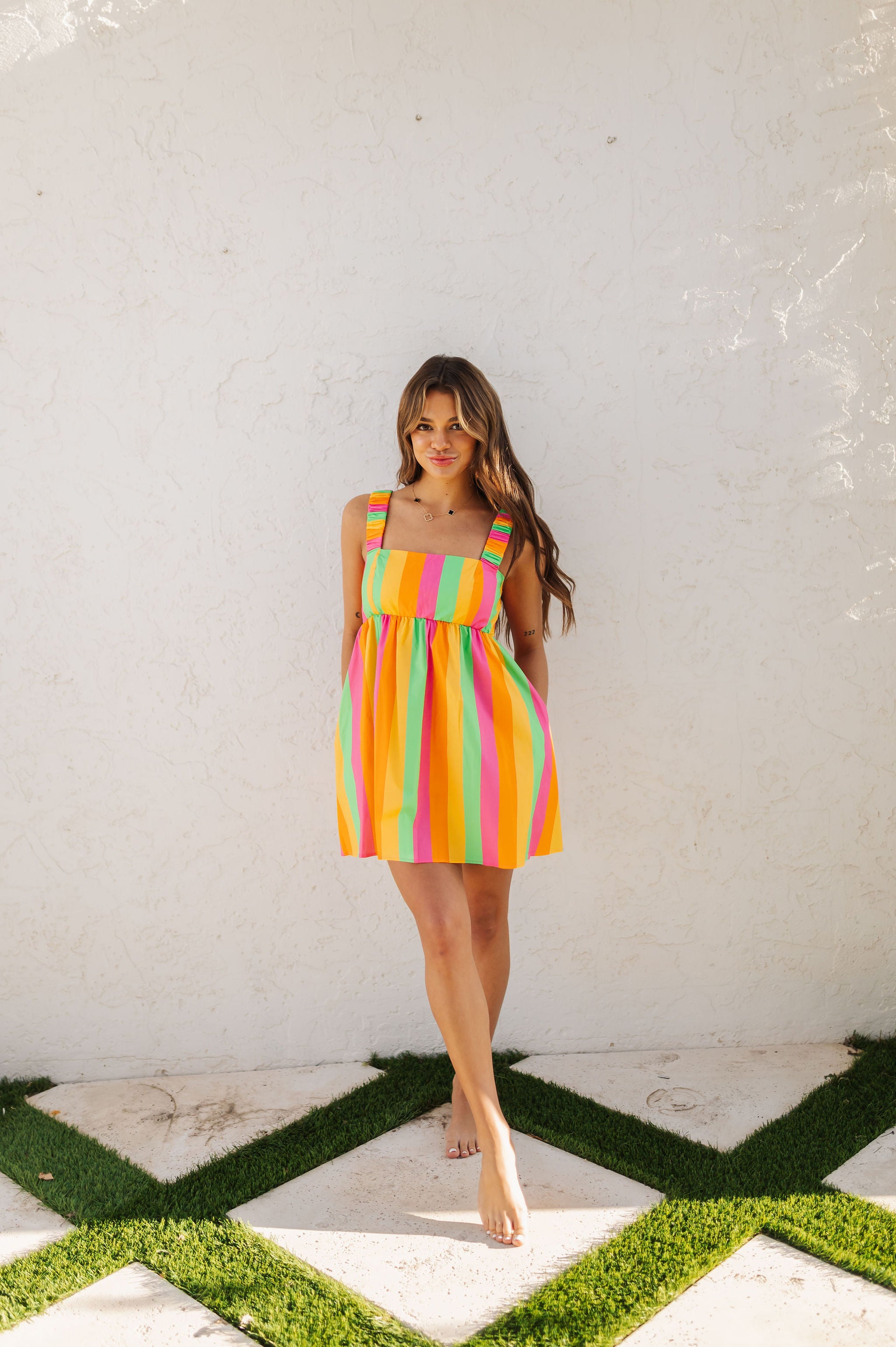 Front view of neon striped Fling Mini Dress with smocked straps. 