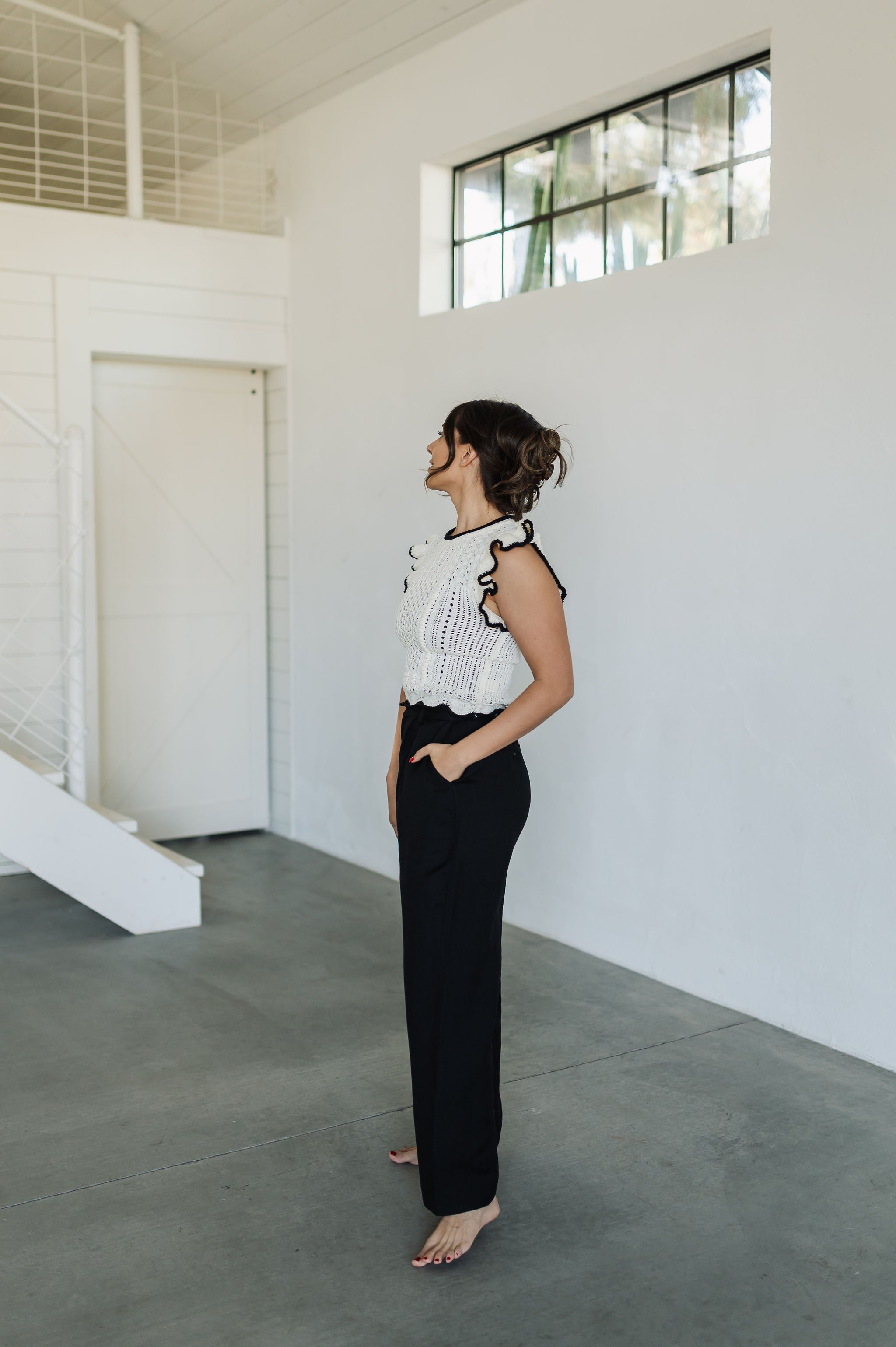 Side view of Chloe Pleat Linen Pant in black with relaxed leg and side pocket. 
