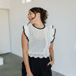 Front view of pointelle knit Piper Knit Top with ruffled sleeves and hem and contrast piping detail.