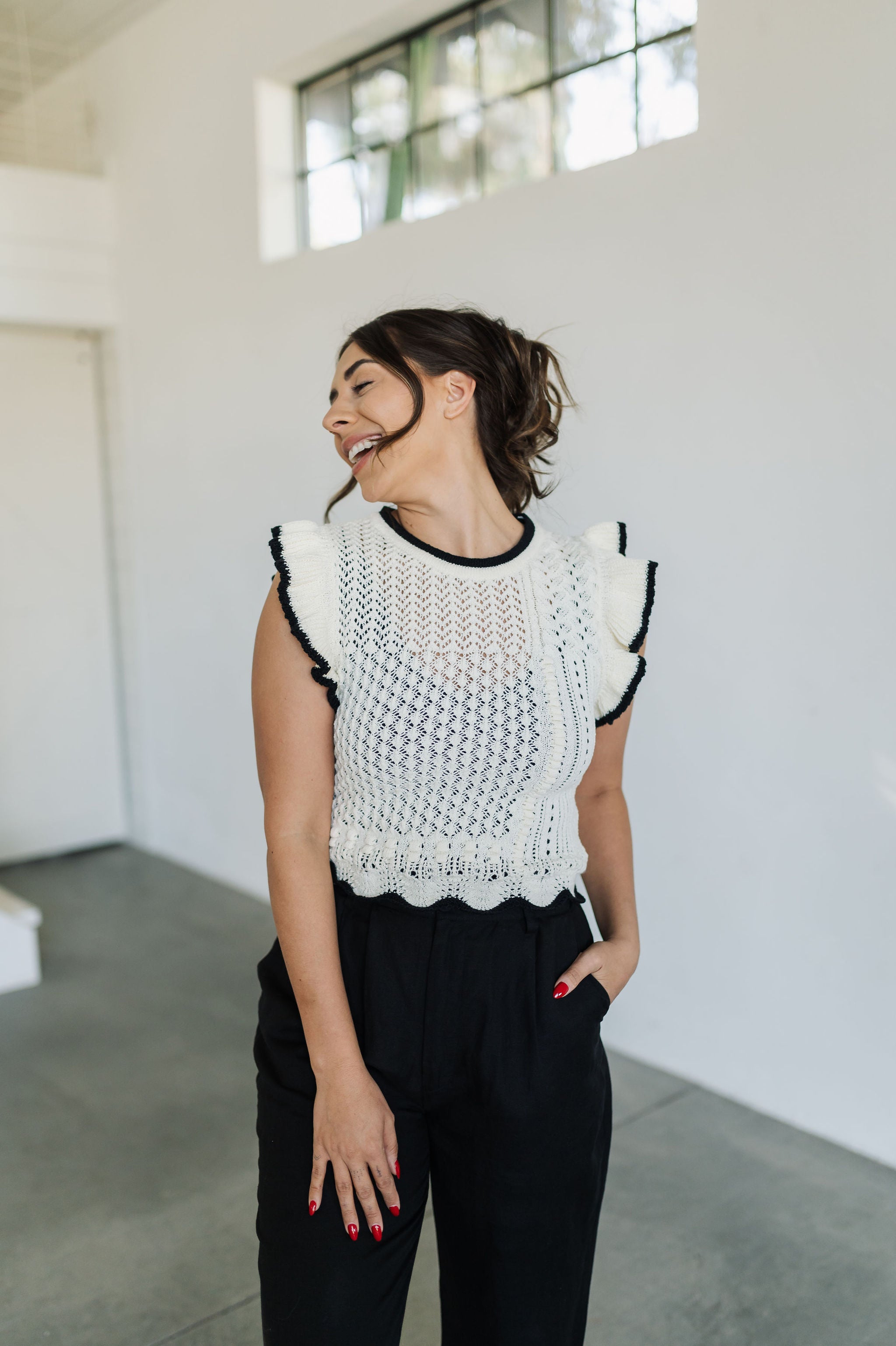 Front view of pointelle knit Piper Knit Top with ruffled sleeves and hem and contrast piping detail.